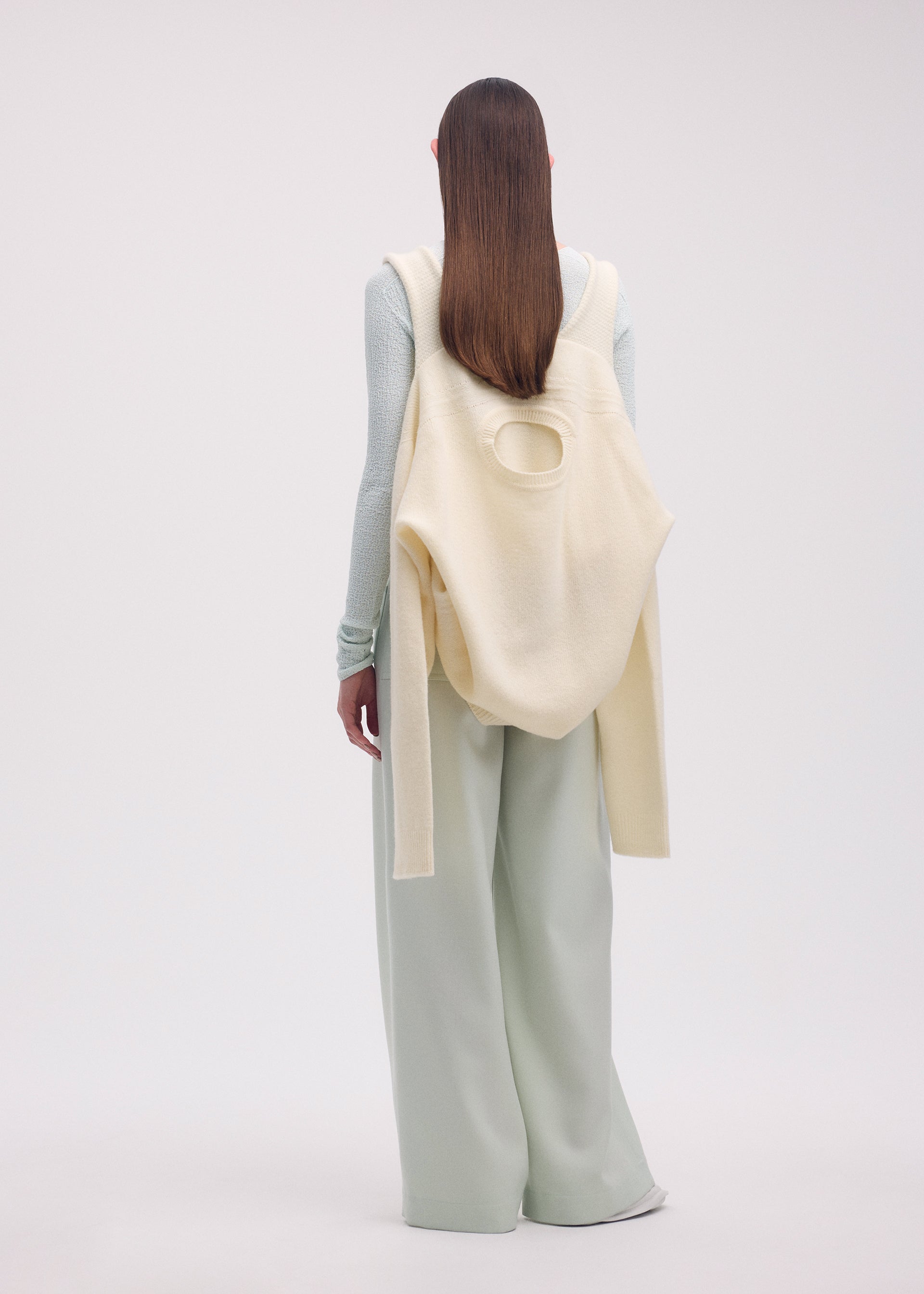 A model wears the ISSEY MIYAKE BACKPACK KNIT top.