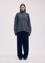 A model wears the ISSEY MIYAKE BACKPACK KNIT top.