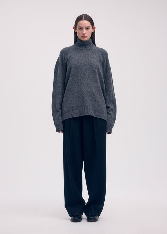 A model wears the ISSEY MIYAKE BACKPACK KNIT top.