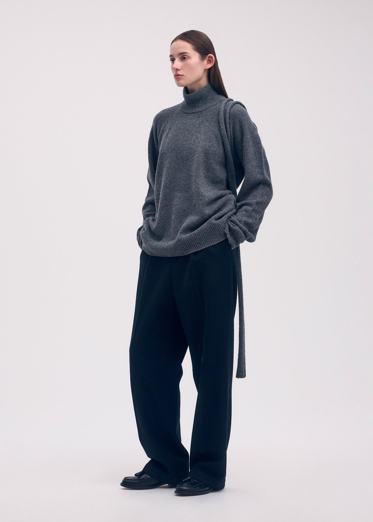 A model wears the ISSEY MIYAKE BACKPACK KNIT top.