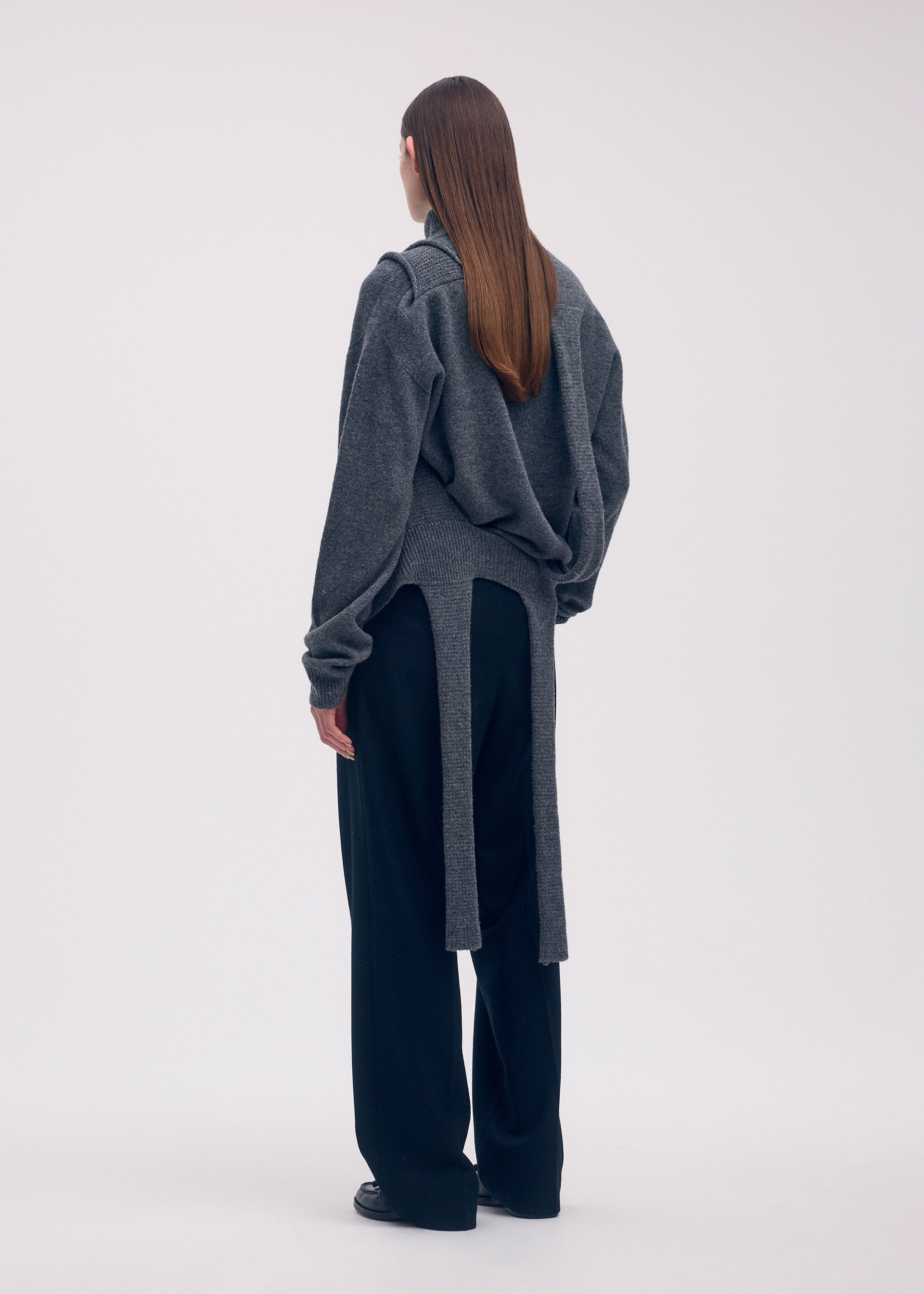 A model wears the ISSEY MIYAKE BACKPACK KNIT top.