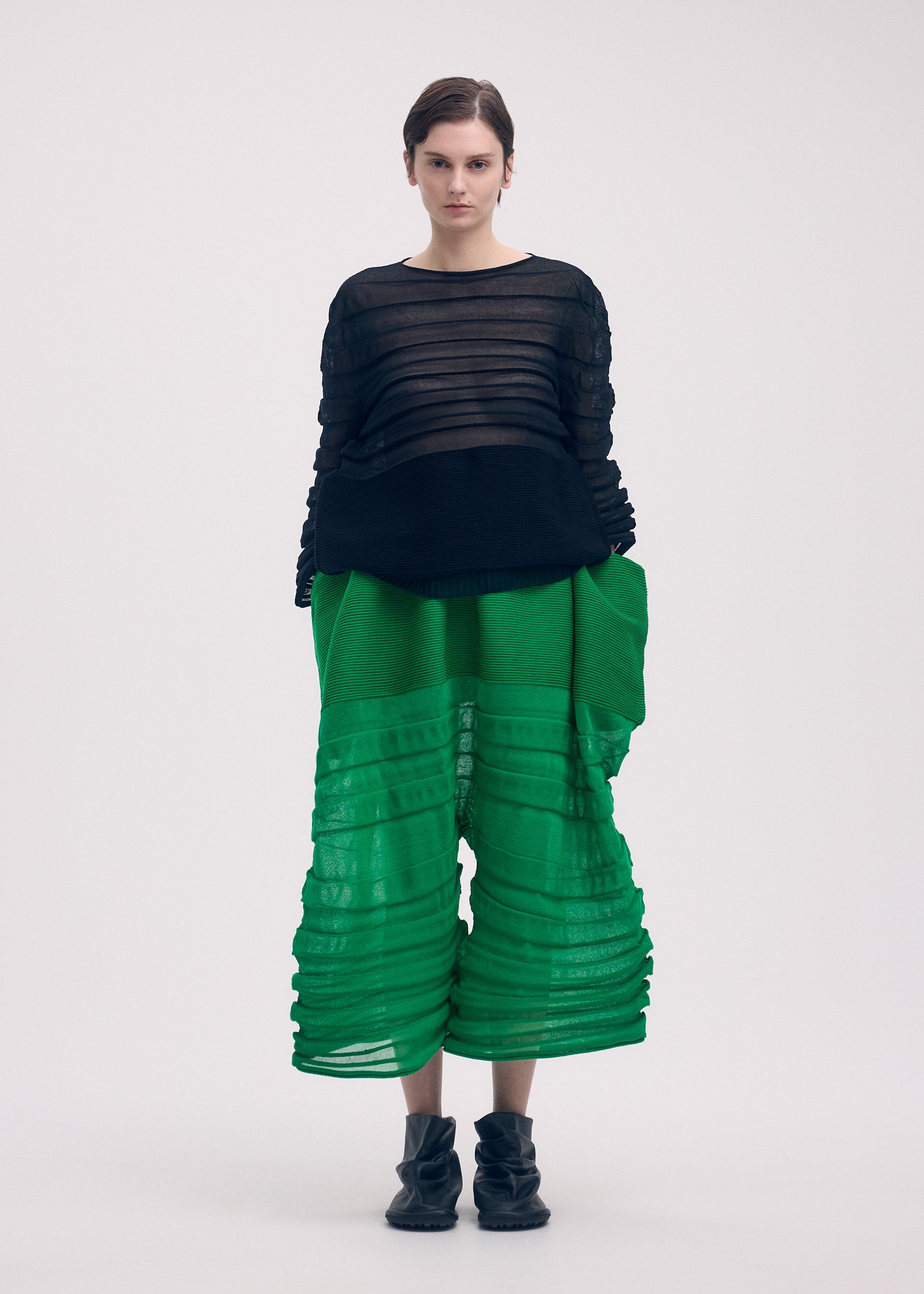 A model wears the ISSEY MIYAKE MOVING KNIT clothing.