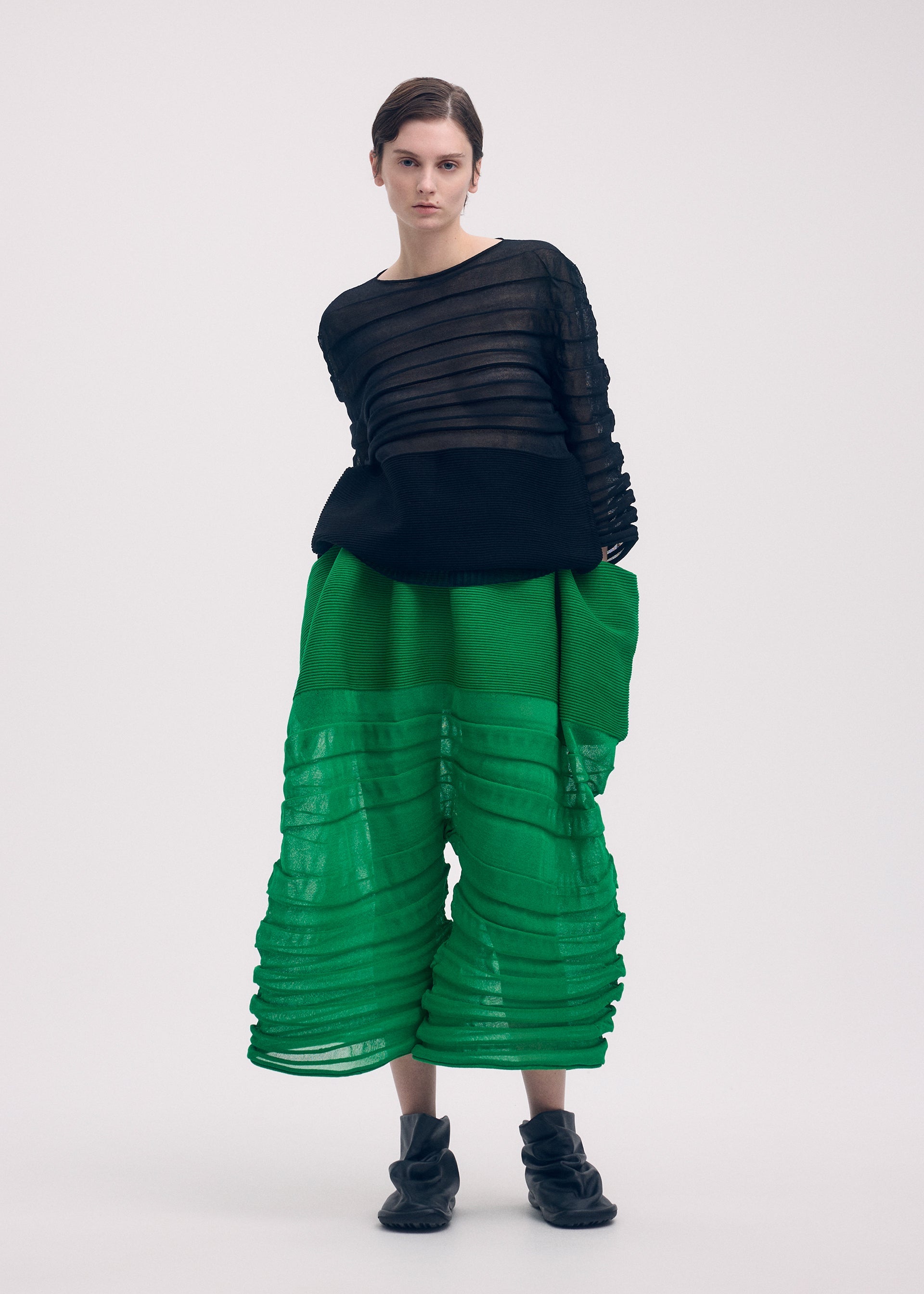 A model wears the ISSEY MIYAKE MOVING KNIT clothing.