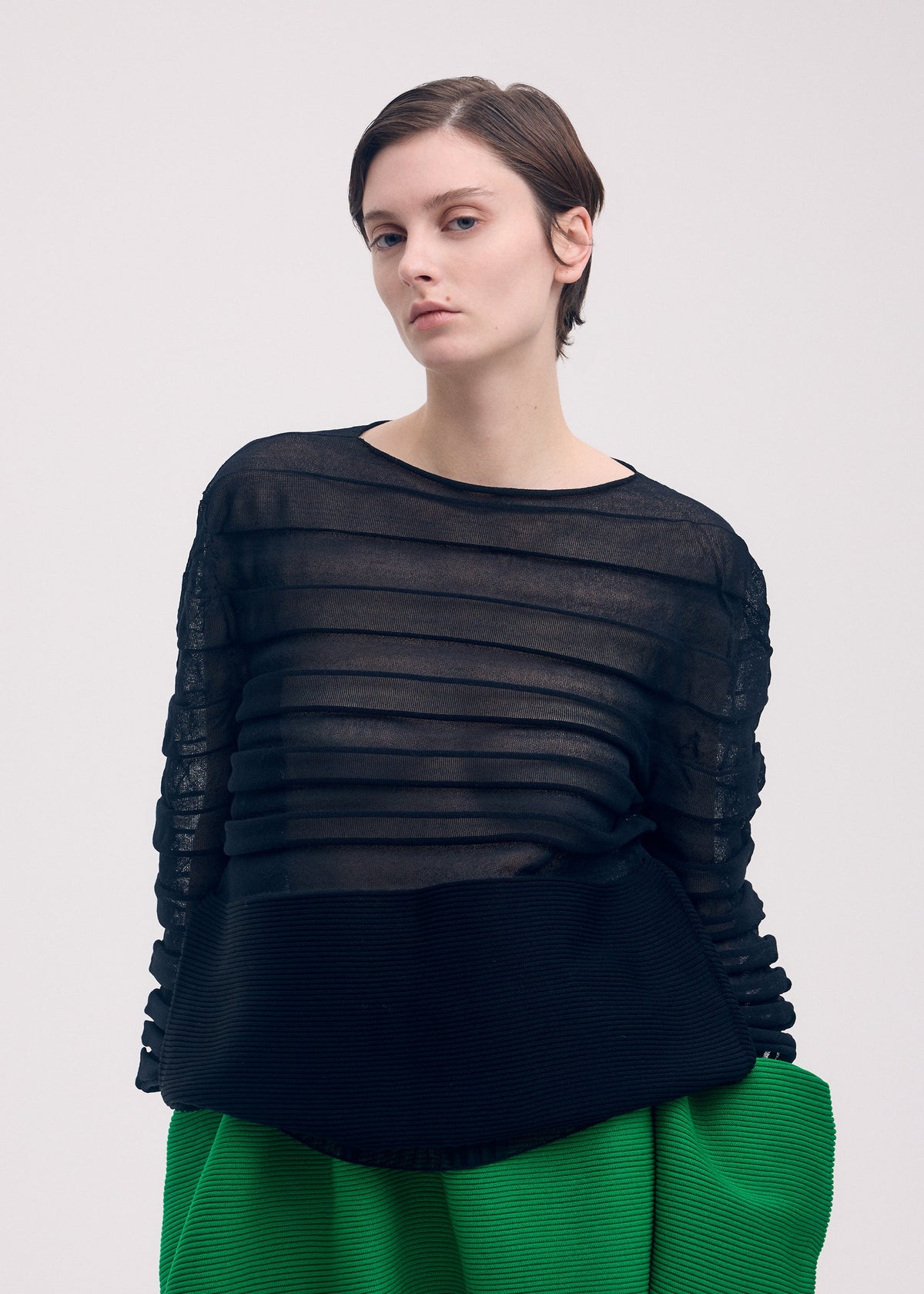 A model wears the ISSEY MIYAKE MOVING KNIT clothing.
