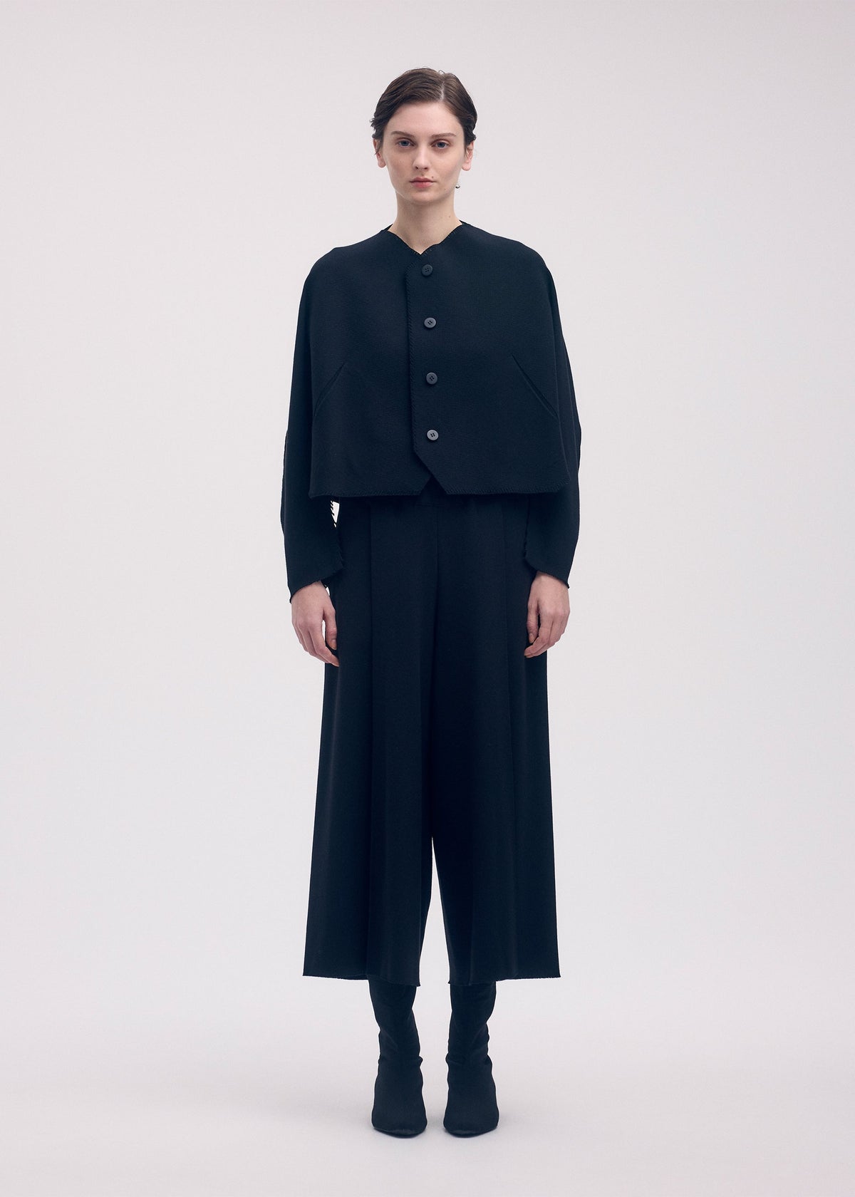 A model wears the ISSEY MIYAKE CAMPAGNE cardigan.