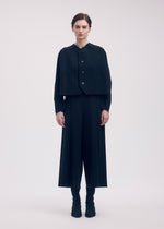 A model wears the ISSEY MIYAKE CAMPAGNE cardigan.