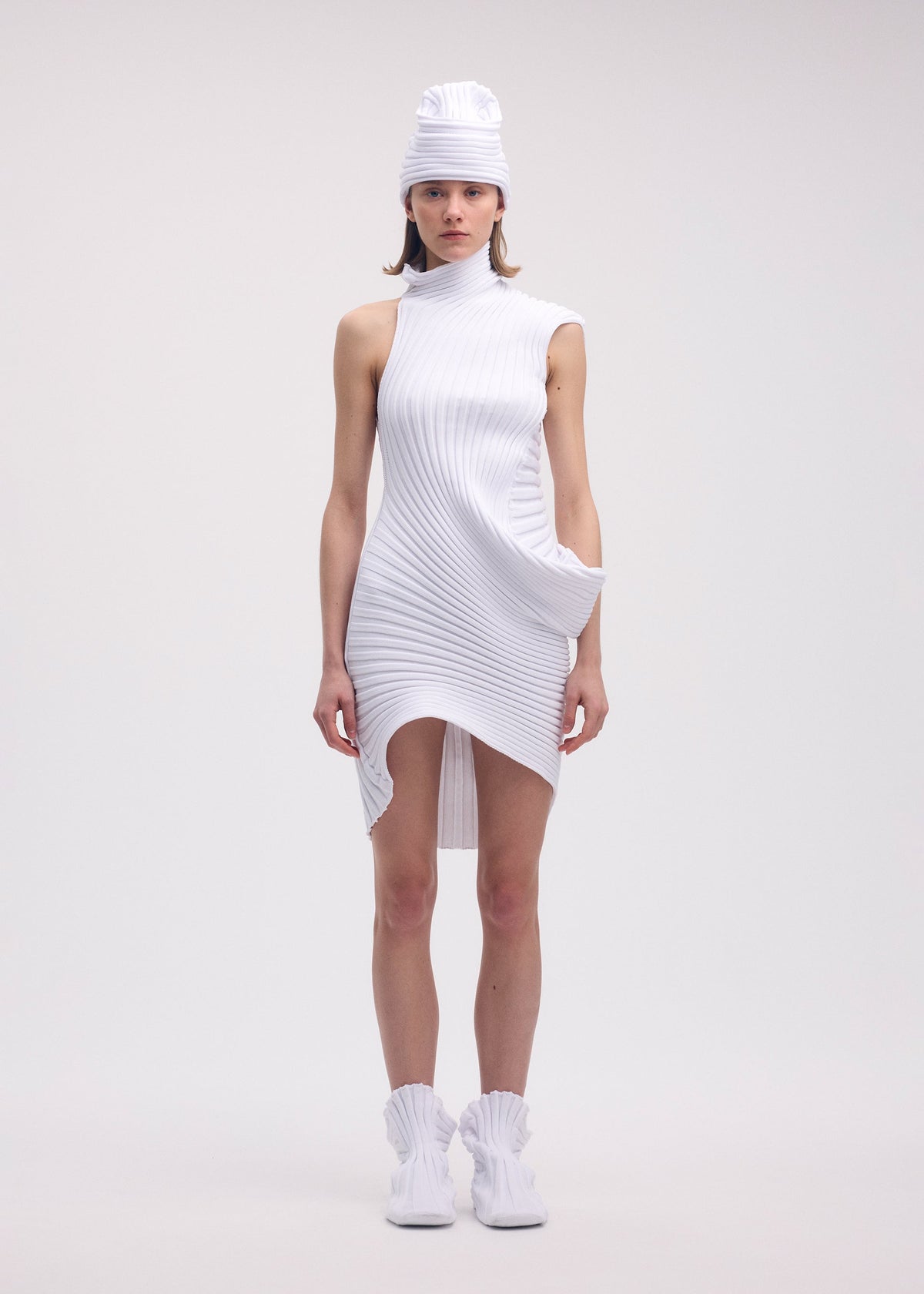 A model wears the ISSEY MIYAKE KNIT (AS IT IS) tunic.
