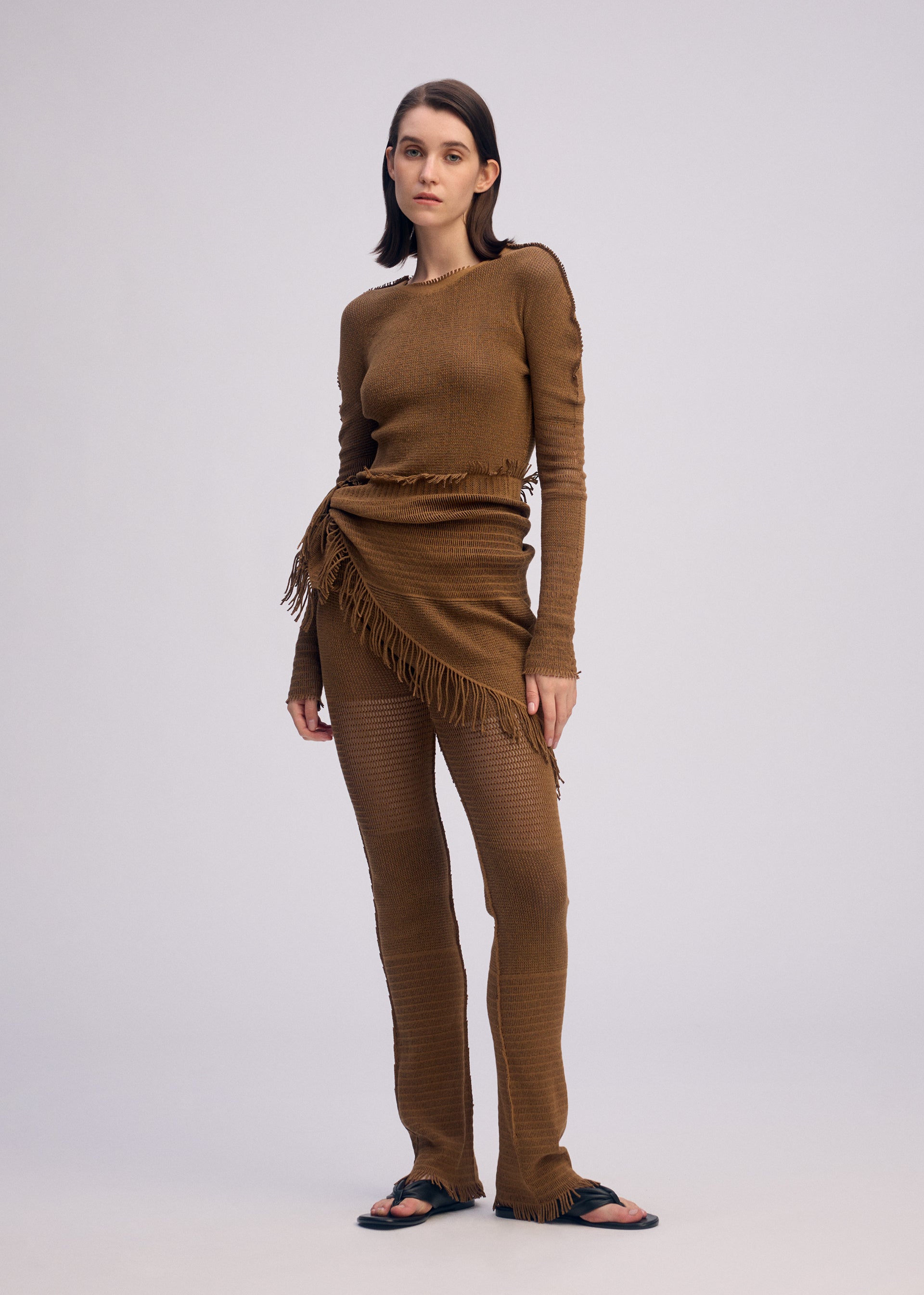 A model wears the ISSEY MIYAKE CROCHET AP STOLE stole.
