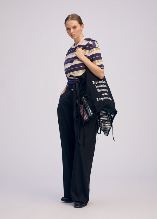 A model wears the ISSEY MIYAKE LIVING TOTE bag.