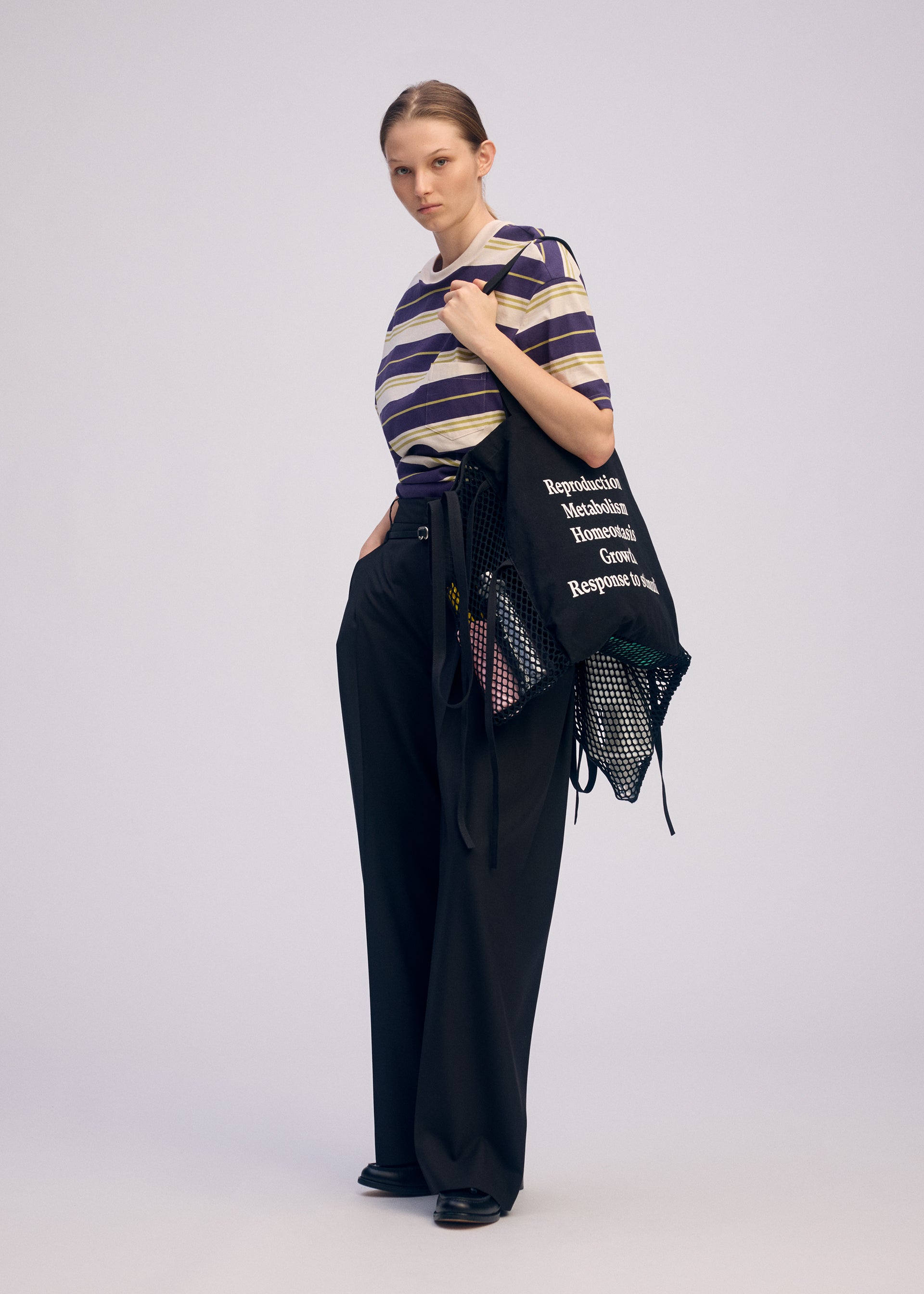 A model wears the ISSEY MIYAKE LIVING TOTE bag.