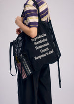 A model wears the ISSEY MIYAKE LIVING TOTE bag.