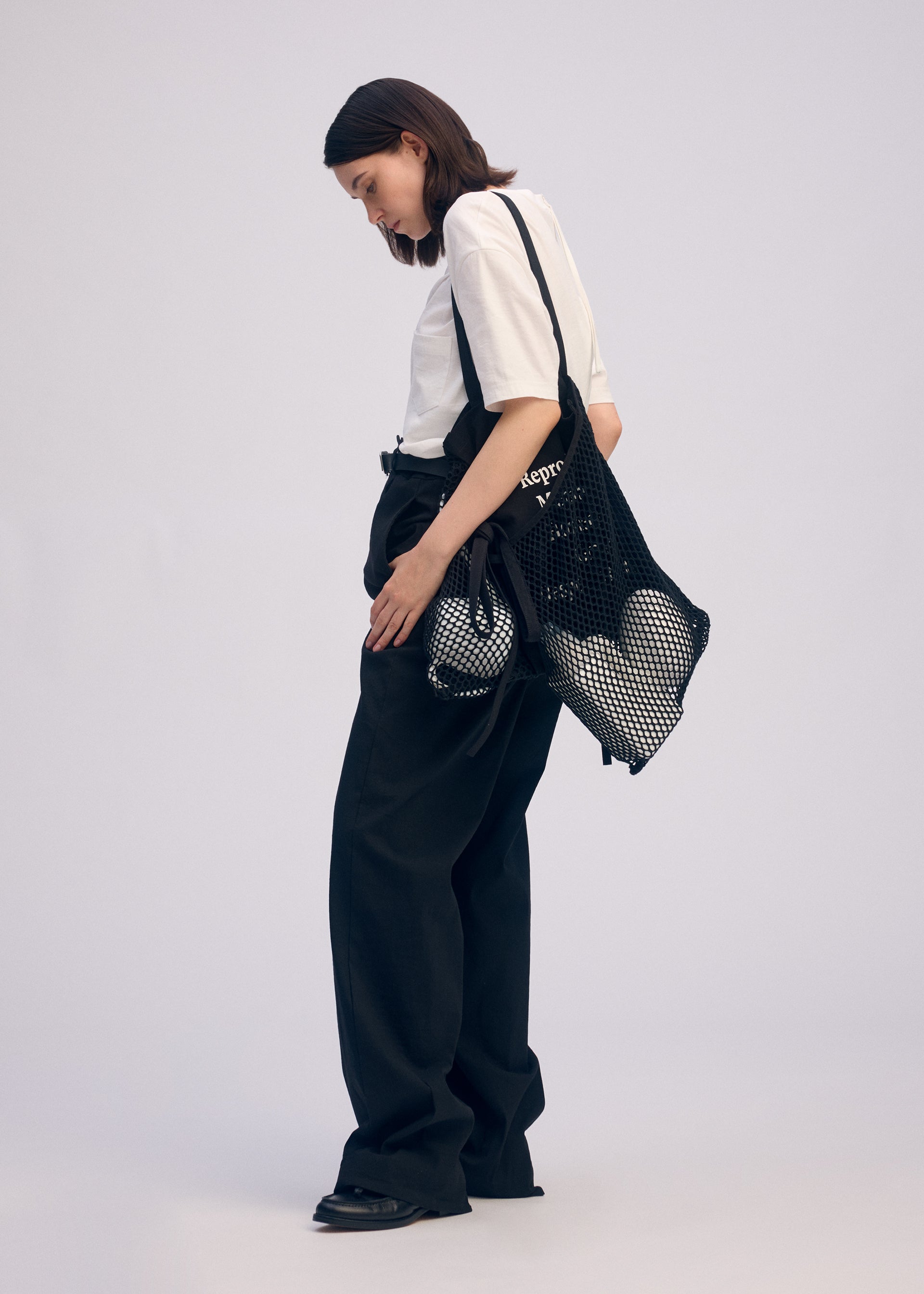 A model wears the ISSEY MIYAKE LIVING TOTE bag.