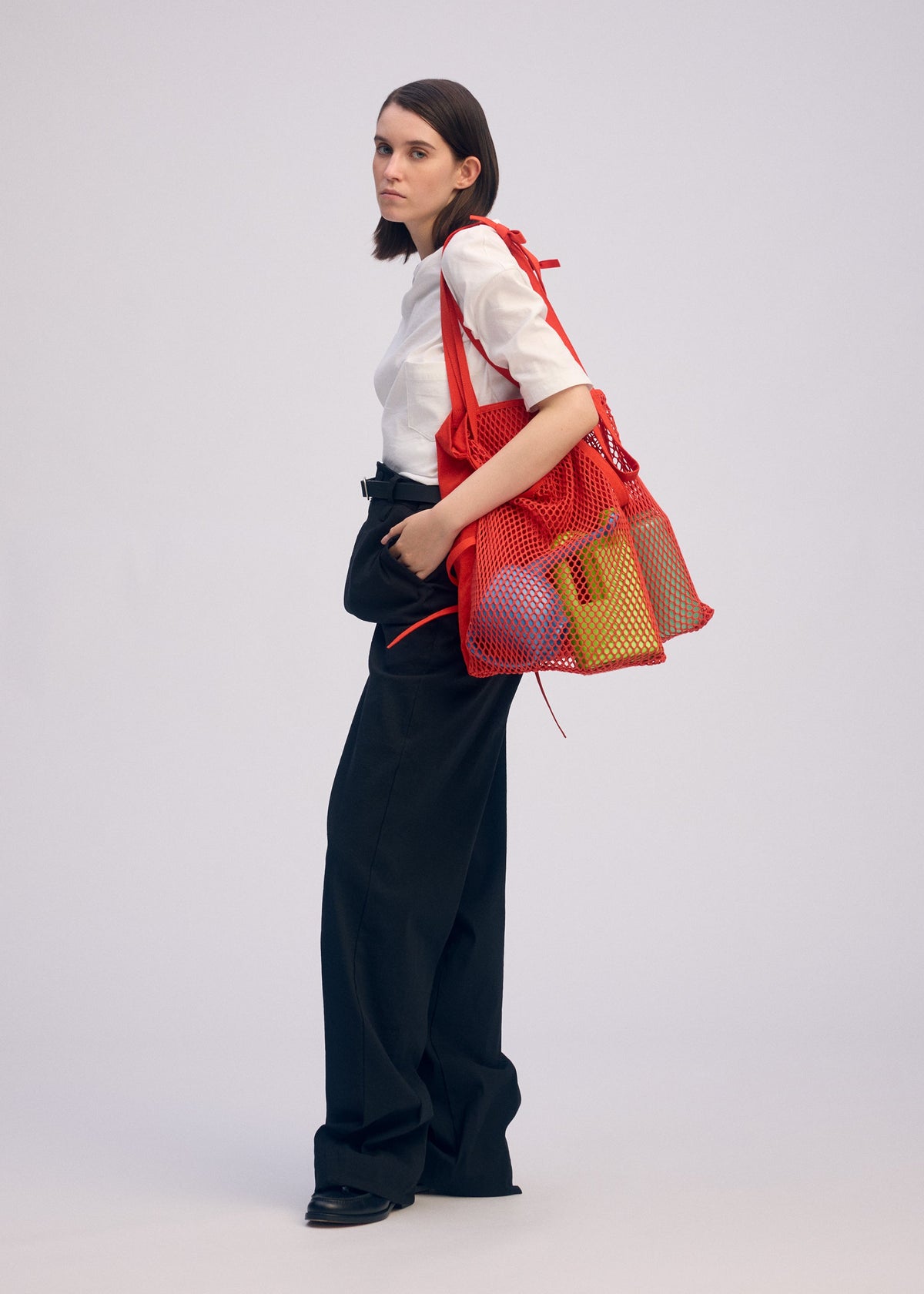 A model wears the ISSEY MIYAKE LIVING TOTE bag.