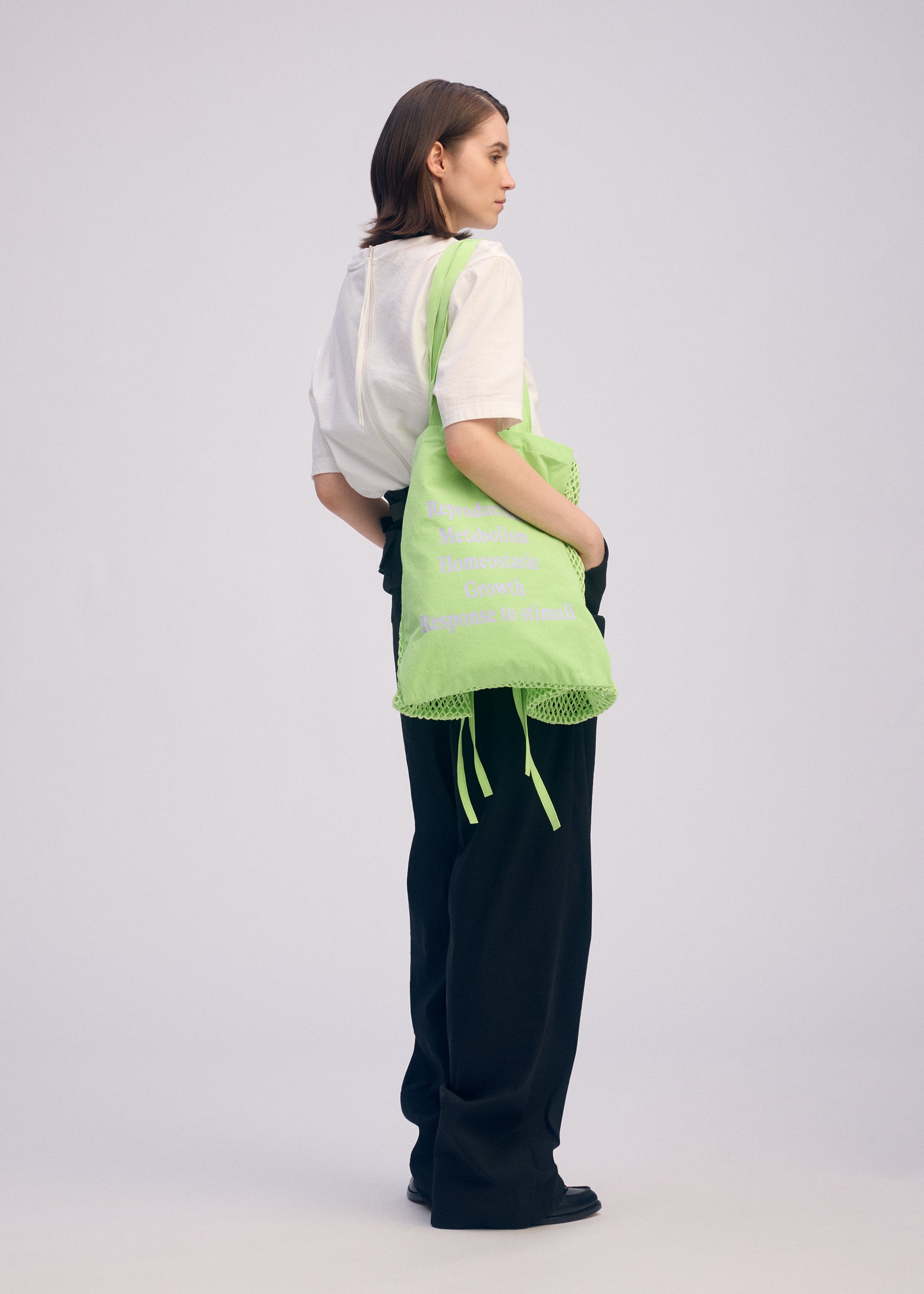 A model wears the ISSEY MIYAKE LIVING TOTE bag.