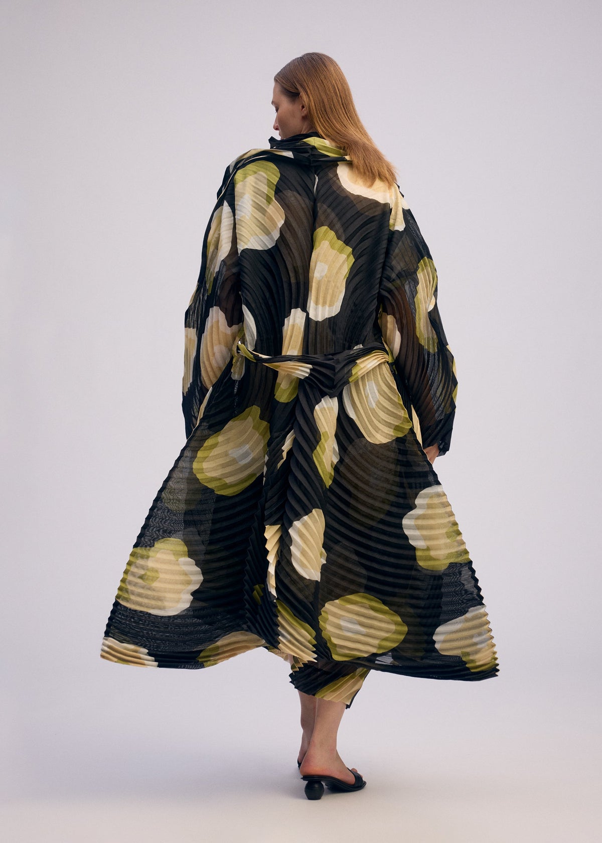 A model wears the ISSEY MIYAKE VERVE coat.
