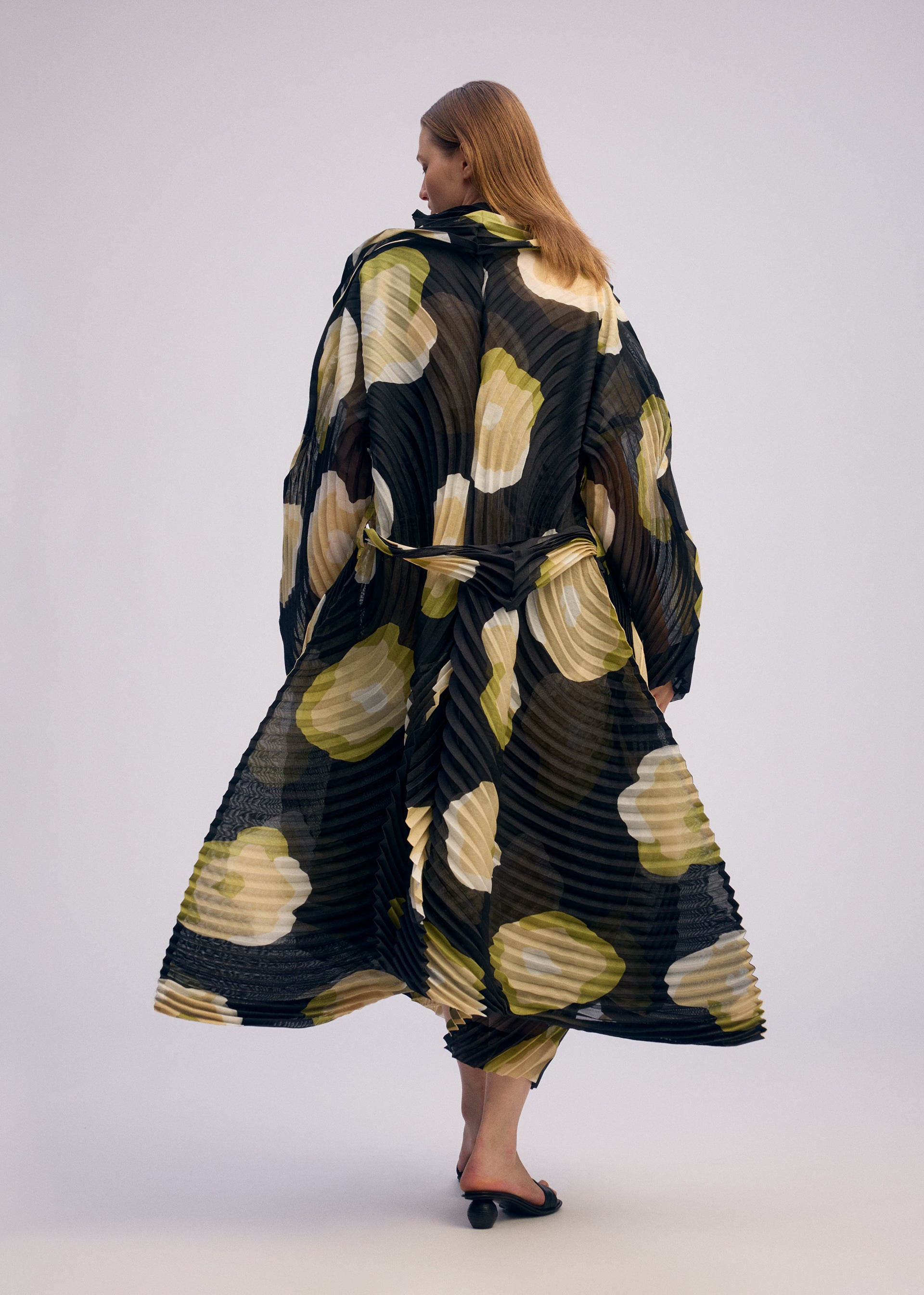 A model wears the ISSEY MIYAKE VERVE coat.