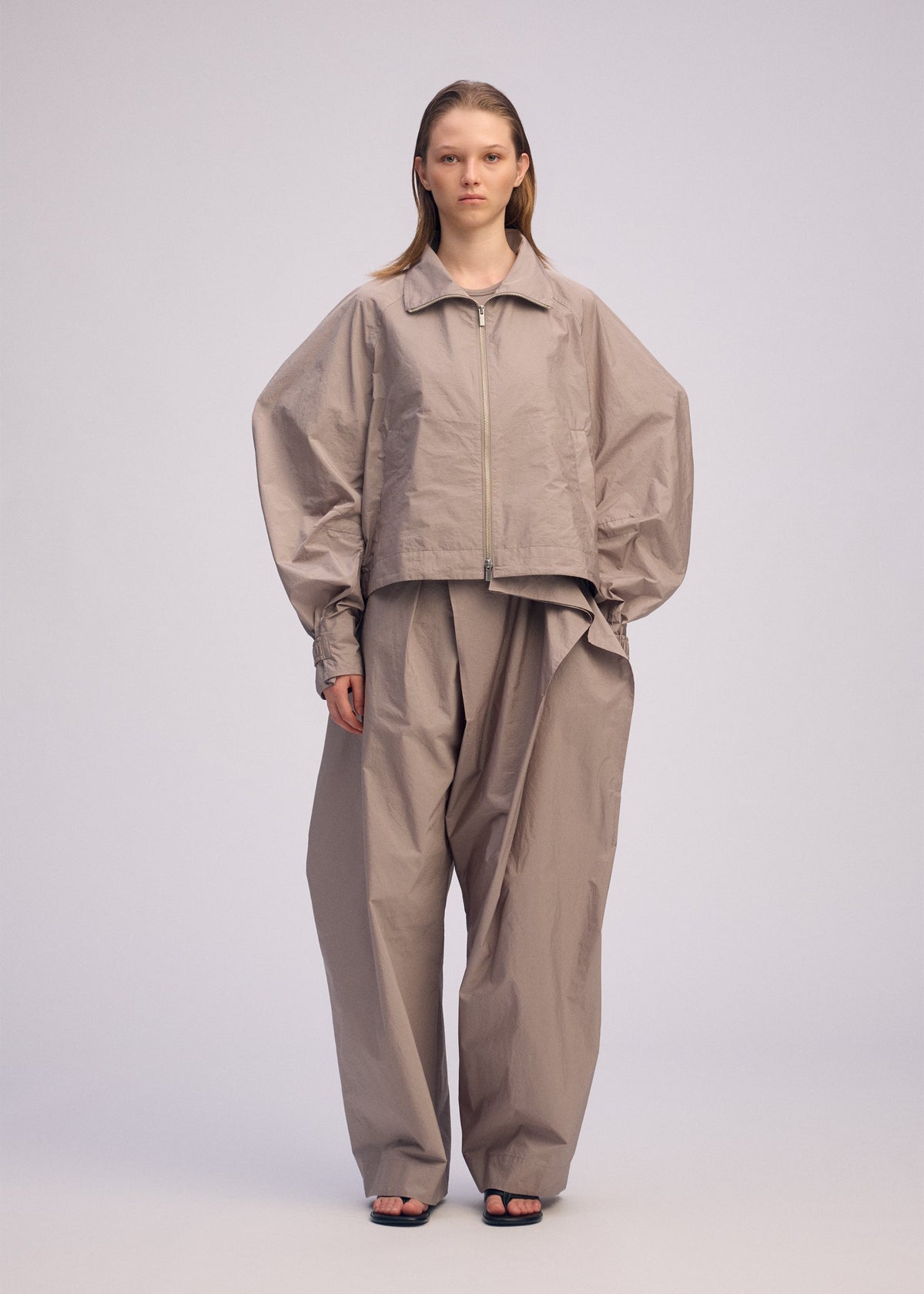 A model wears the ISSEY MIYAKE AKIMBO clothing.
