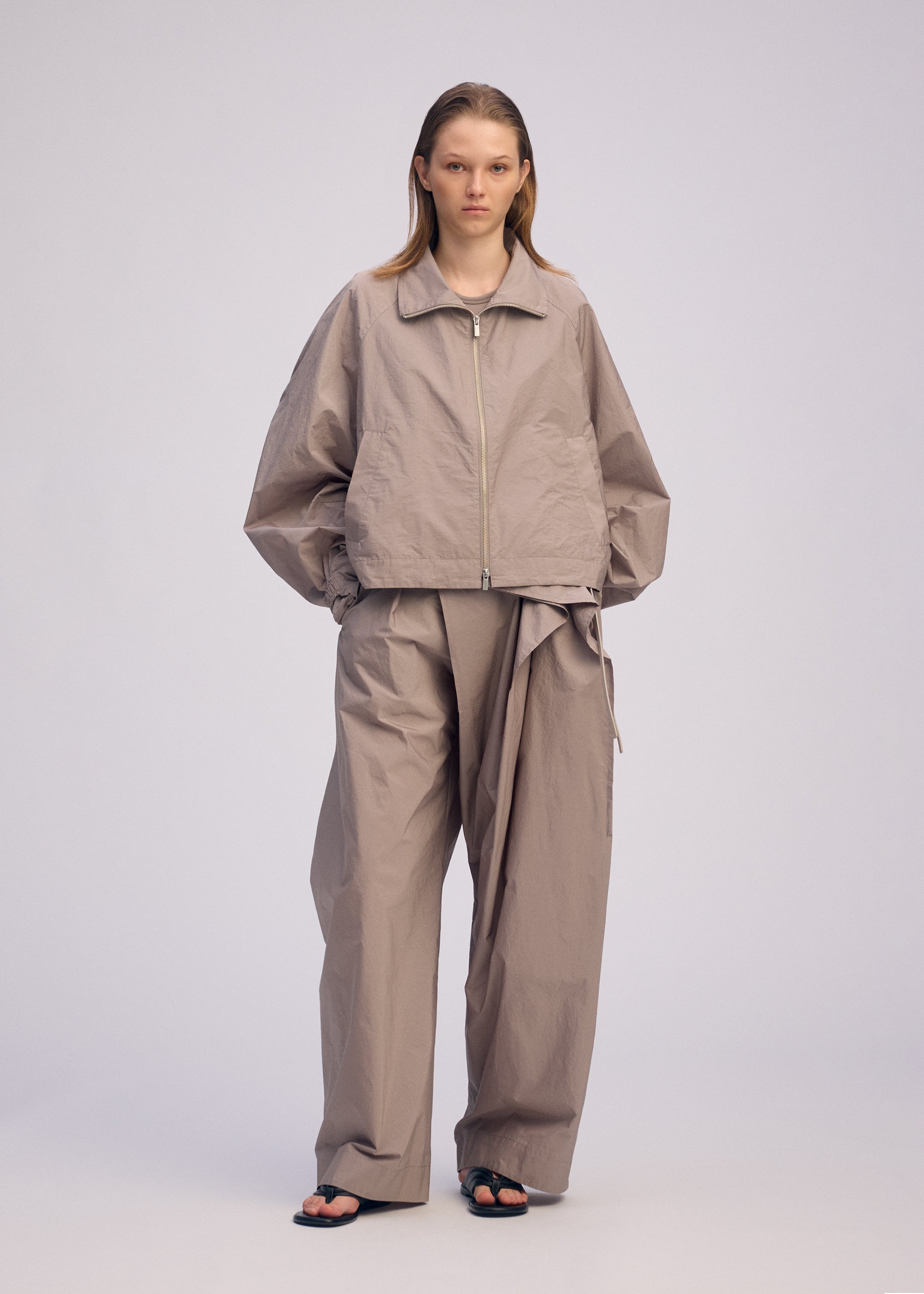 A model wears the ISSEY MIYAKE AKIMBO clothing.