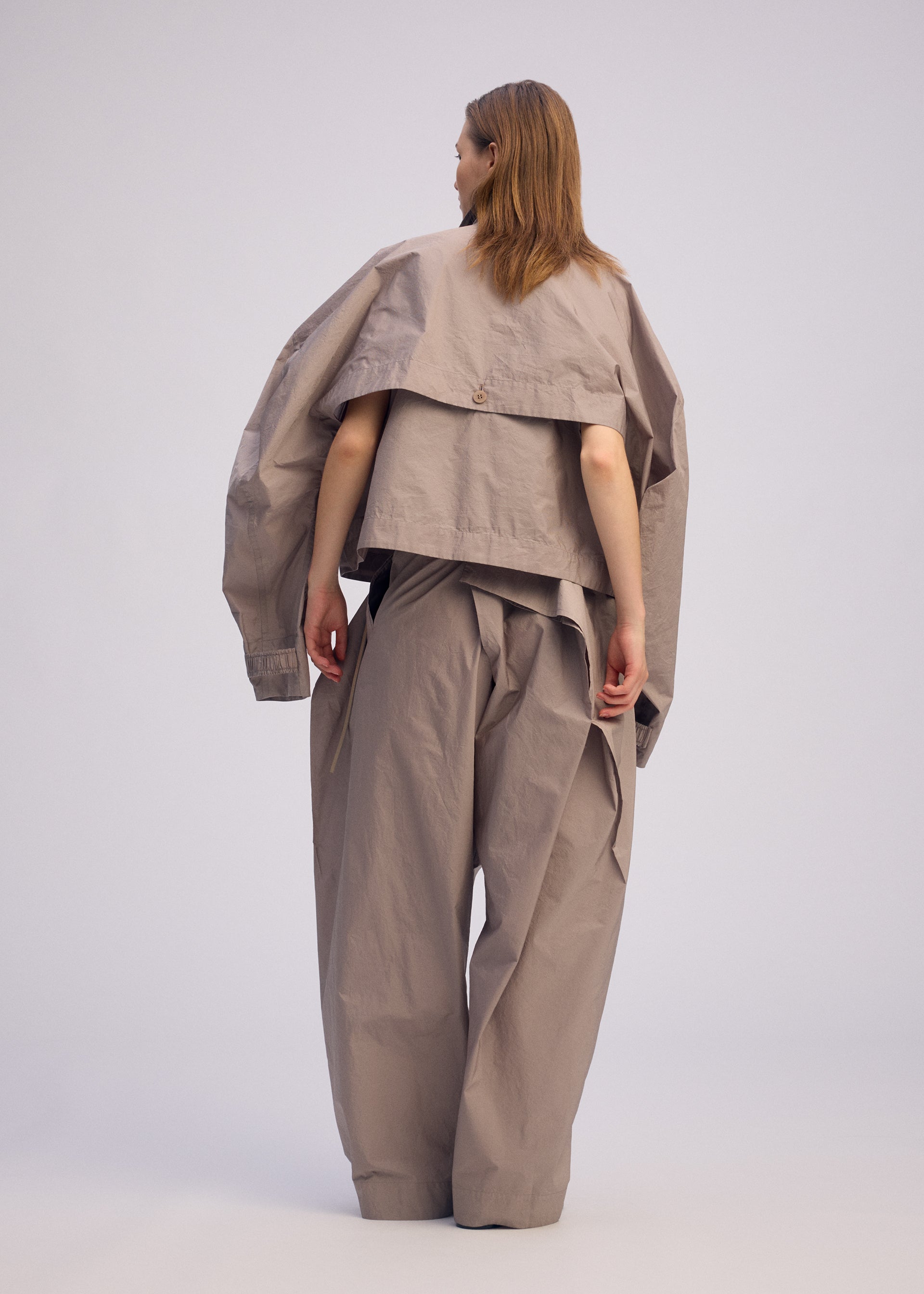 A model wears the ISSEY MIYAKE AKIMBO clothing.