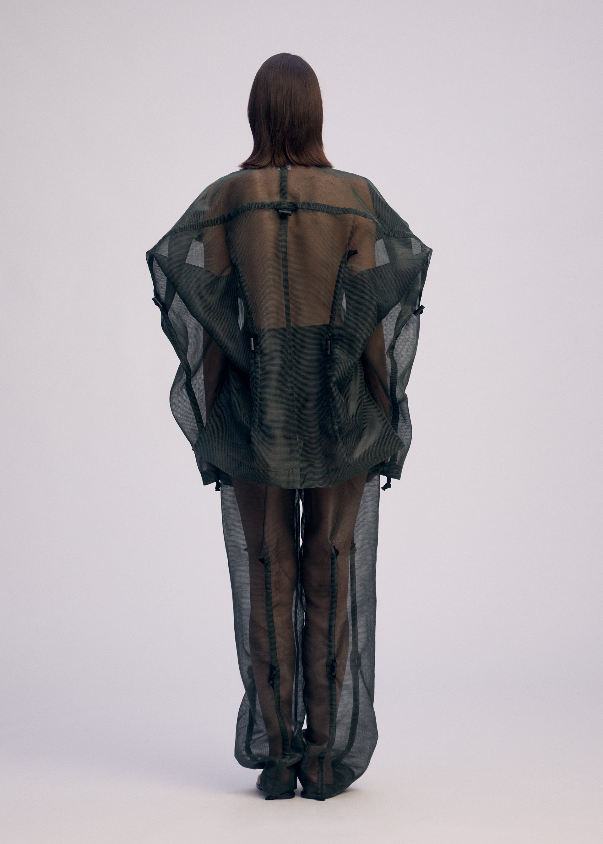 A model wears the ISSEY MIYAKE DRAW TO FORM jacket.