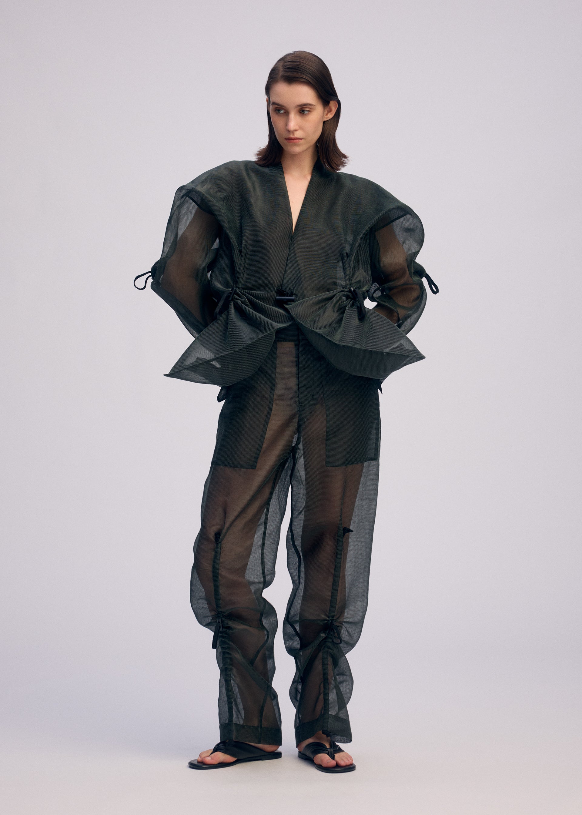 A model wears the ISSEY MIYAKE DRAW TO FORM jacket.