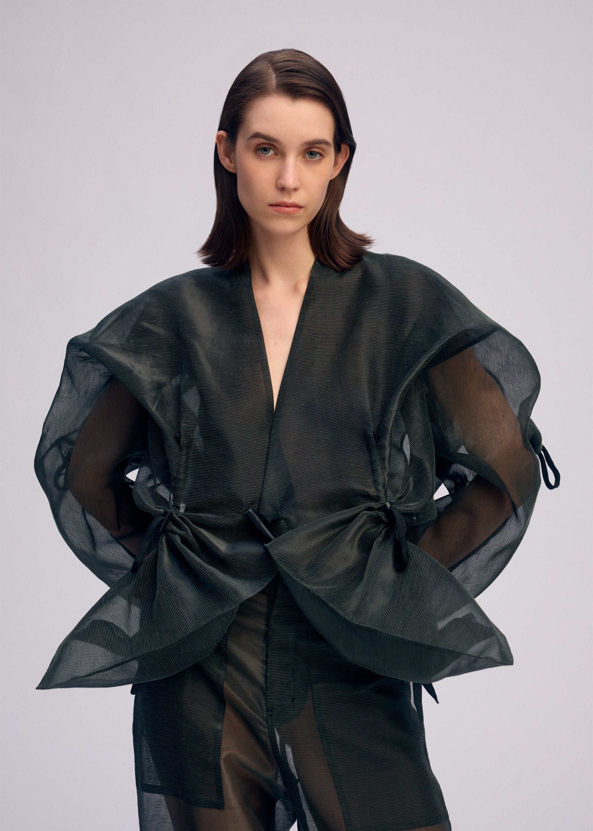 A model wears the ISSEY MIYAKE DRAW TO FORM jacket.