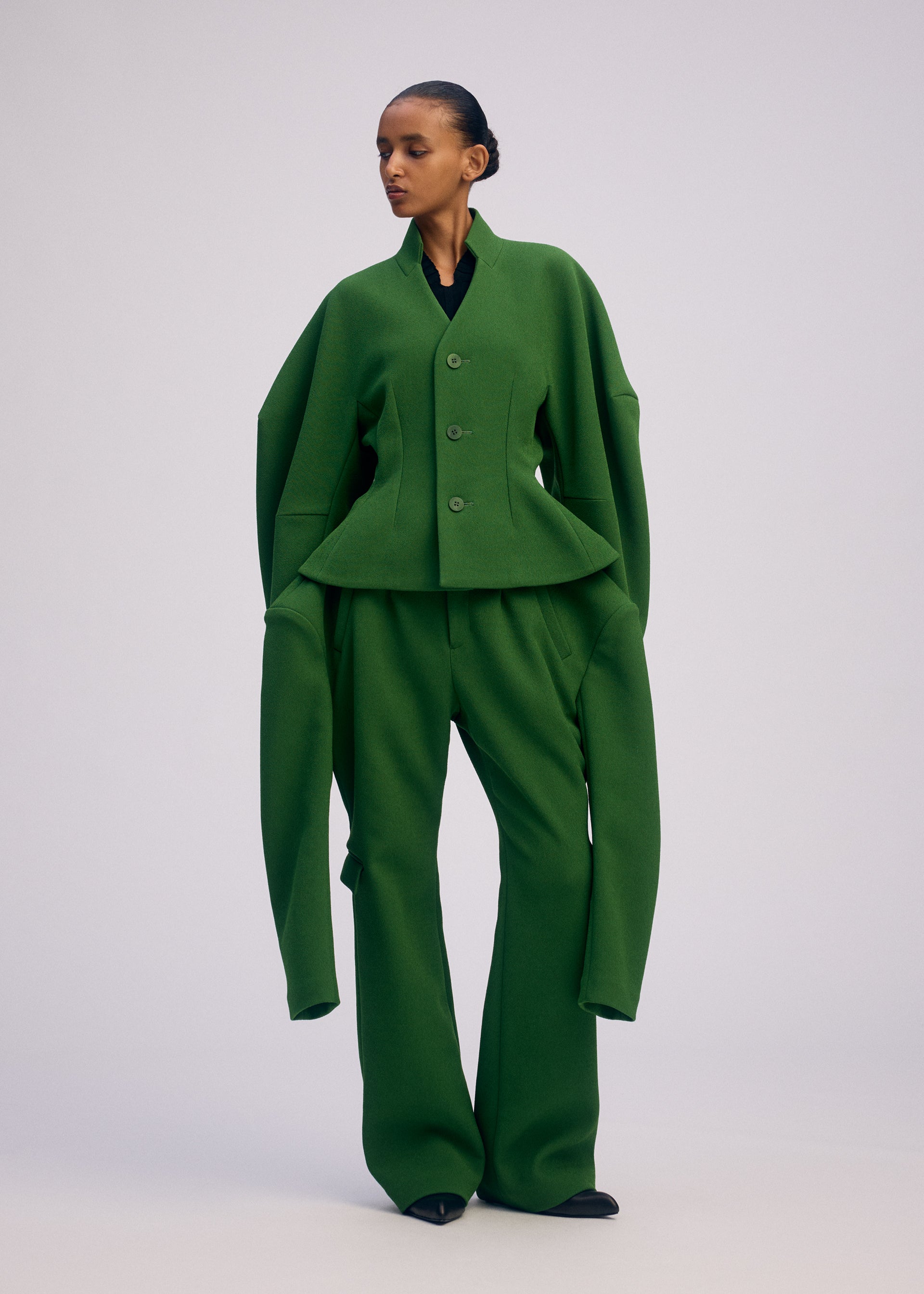 A model wears the ISSEY MIYAKE ARMS clothing.