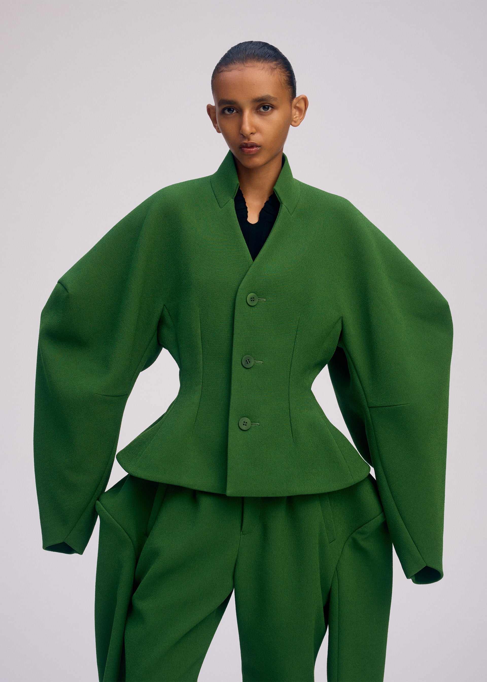 A model wears the ISSEY MIYAKE ARMS clothing.