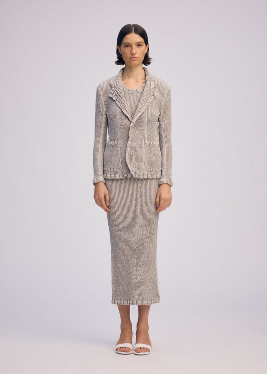 A model wears the ISSEY MIYAKE WAVELET ENSEMBLE jacket.