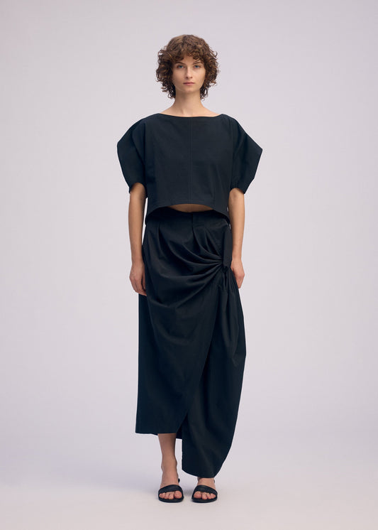 A model wears the ISSEY MIYAKE TWISTED DRAPE trousers.