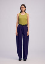 A model wears the ISSEY MIYAKE BELTED WOOL PANTS trousers.
