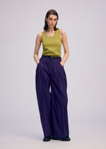 A model wears the ISSEY MIYAKE BELTED WOOL PANTS trousers.