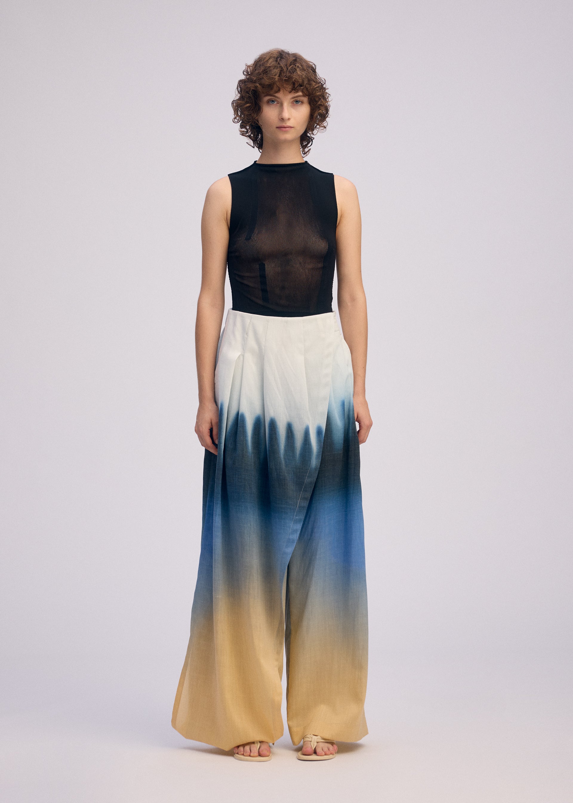 A model wears the ISSEY MIYAKE PLUMAGE plumage-trousers-starling-1.