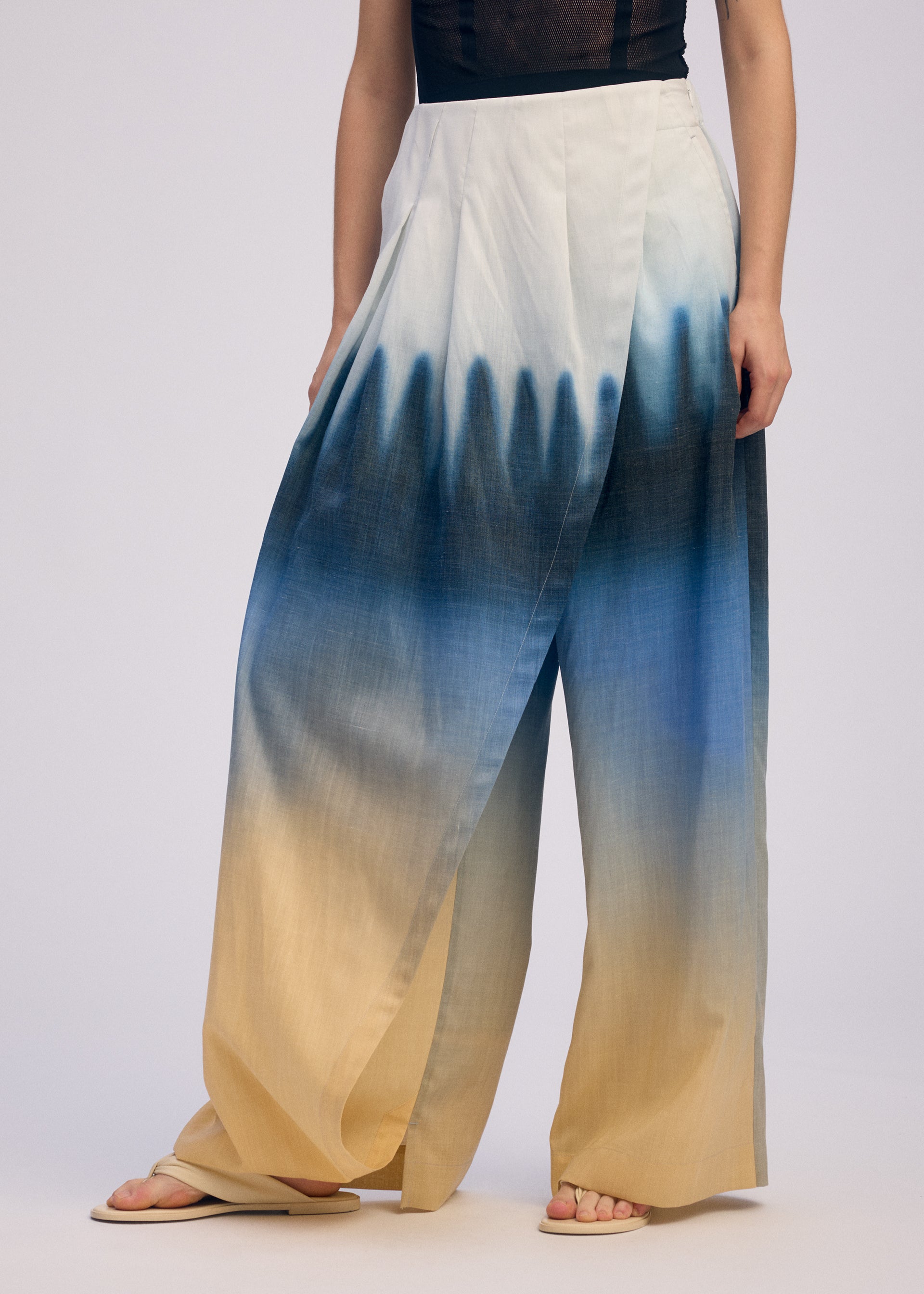 A model wears the ISSEY MIYAKE PLUMAGE plumage-trousers-chukar-1.