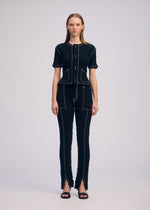 A model wears the ISSEY MIYAKE WAVELET ENSEMBLE trousers.