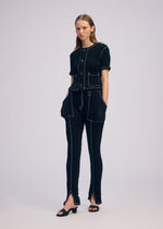 A model wears the ISSEY MIYAKE WAVELET ENSEMBLE trousers.