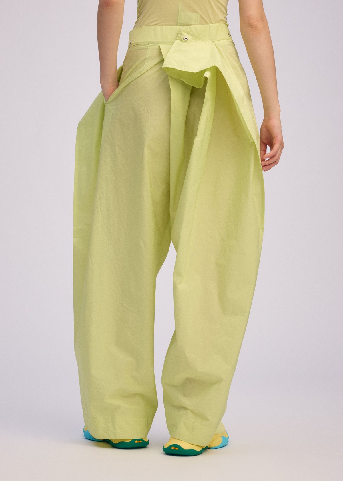 A model wears the ISSEY MIYAKE AKIMBO clothing.