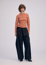 A model wears the ISSEY MIYAKE FLUTTERING PANTS trousers.