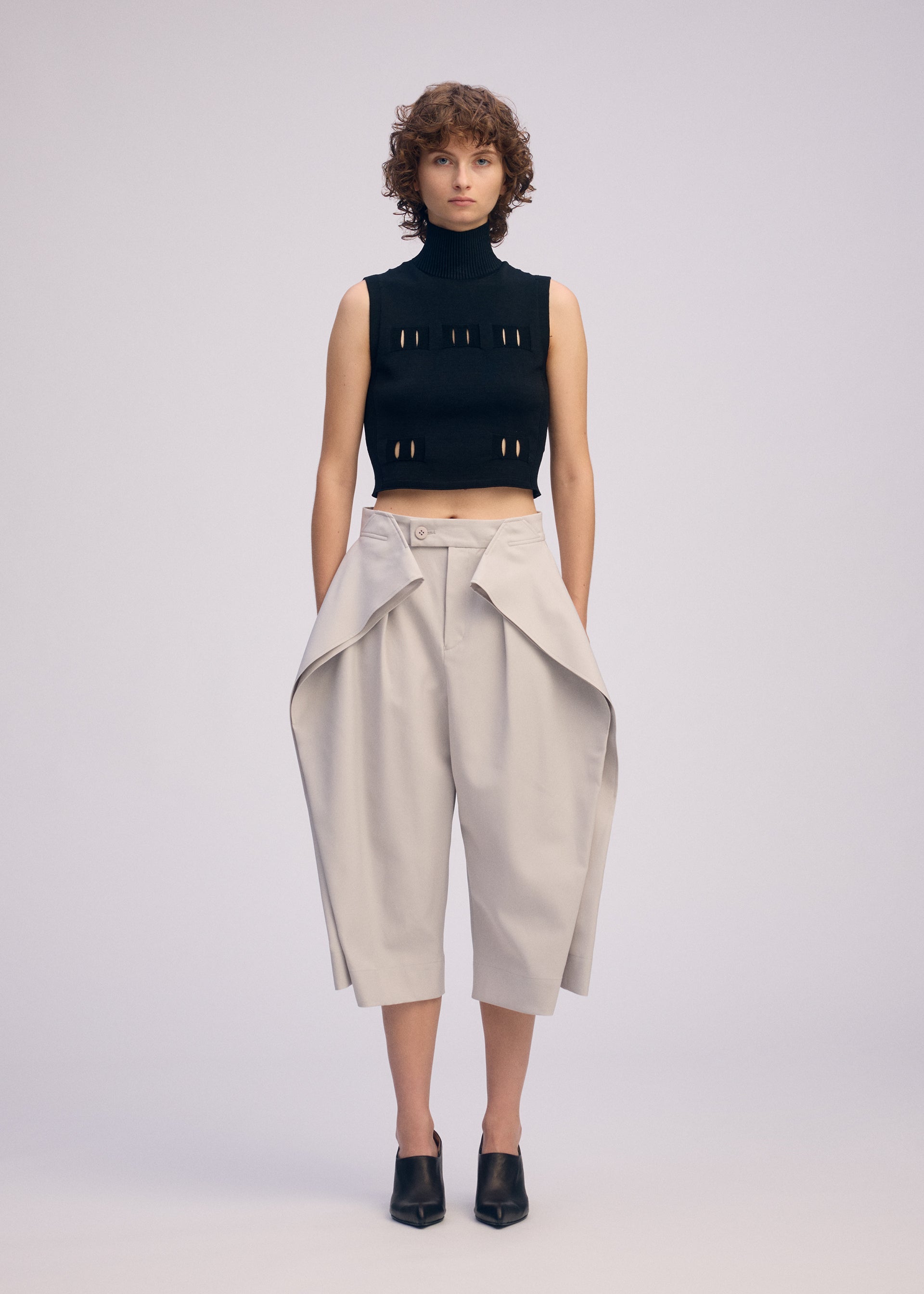 A model wears the ISSEY MIYAKE FLUTTERING PANTS trousers.