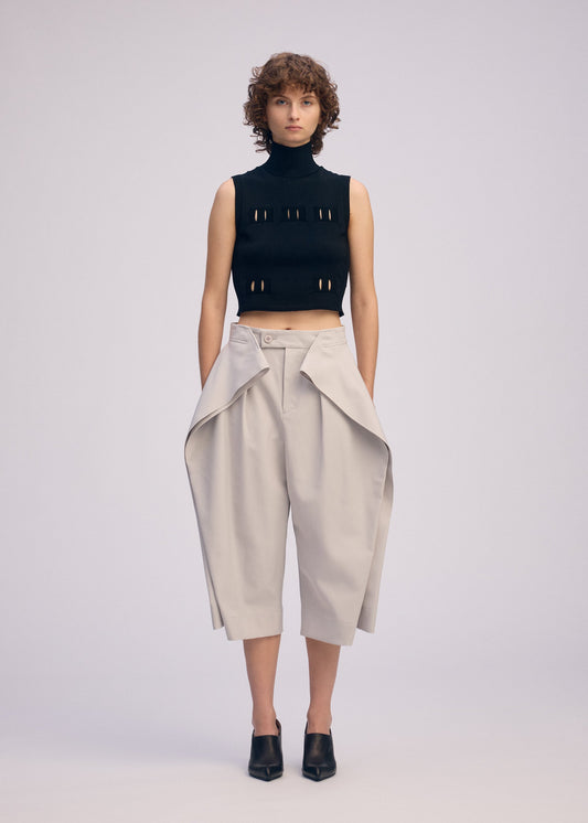 A model wears the ISSEY MIYAKE FLUTTERING PANTS trousers.