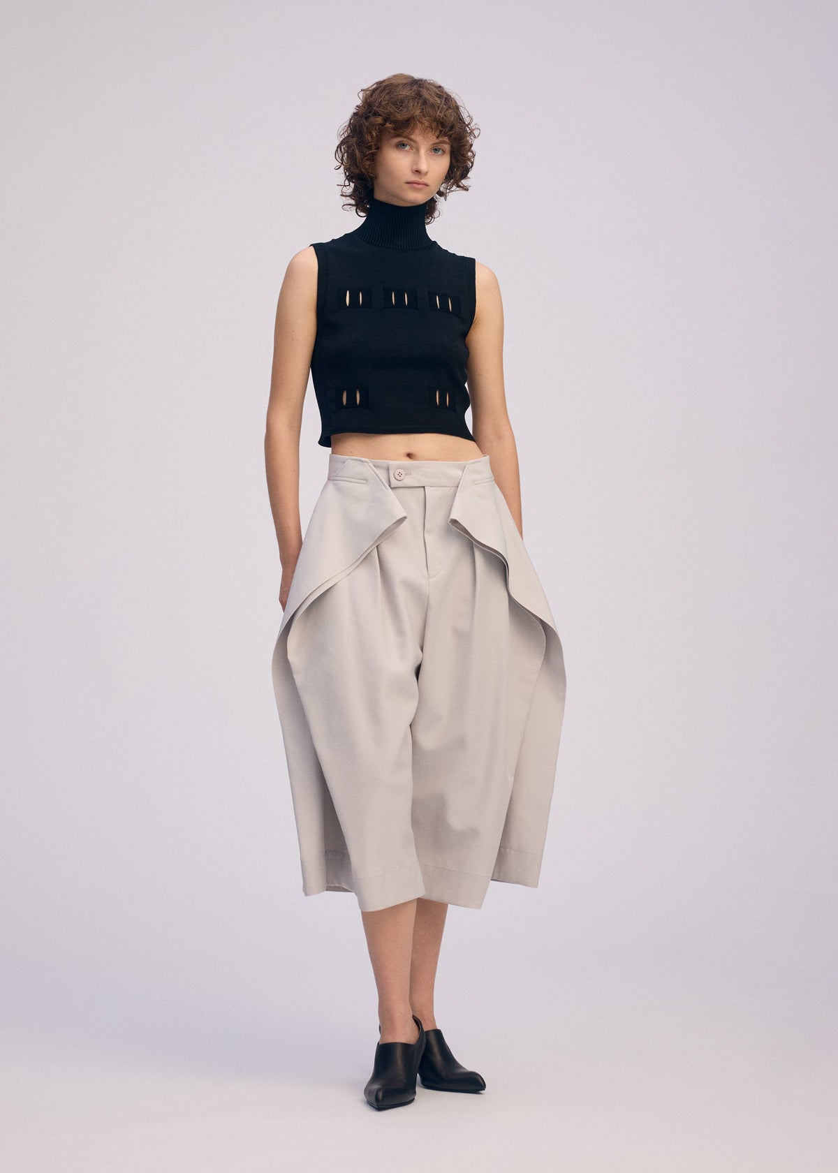 A model wears the ISSEY MIYAKE FLUTTERING PANTS trousers.