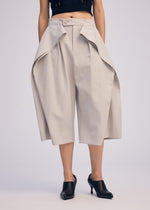 A model wears the ISSEY MIYAKE FLUTTERING PANTS trousers.
