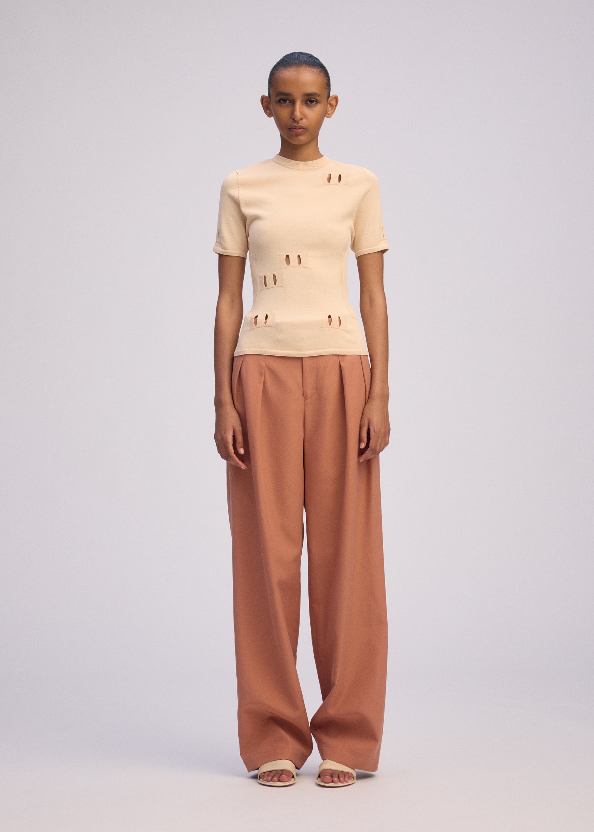 A model wears the ISSEY MIYAKE FLUTTERING PANTS trousers.