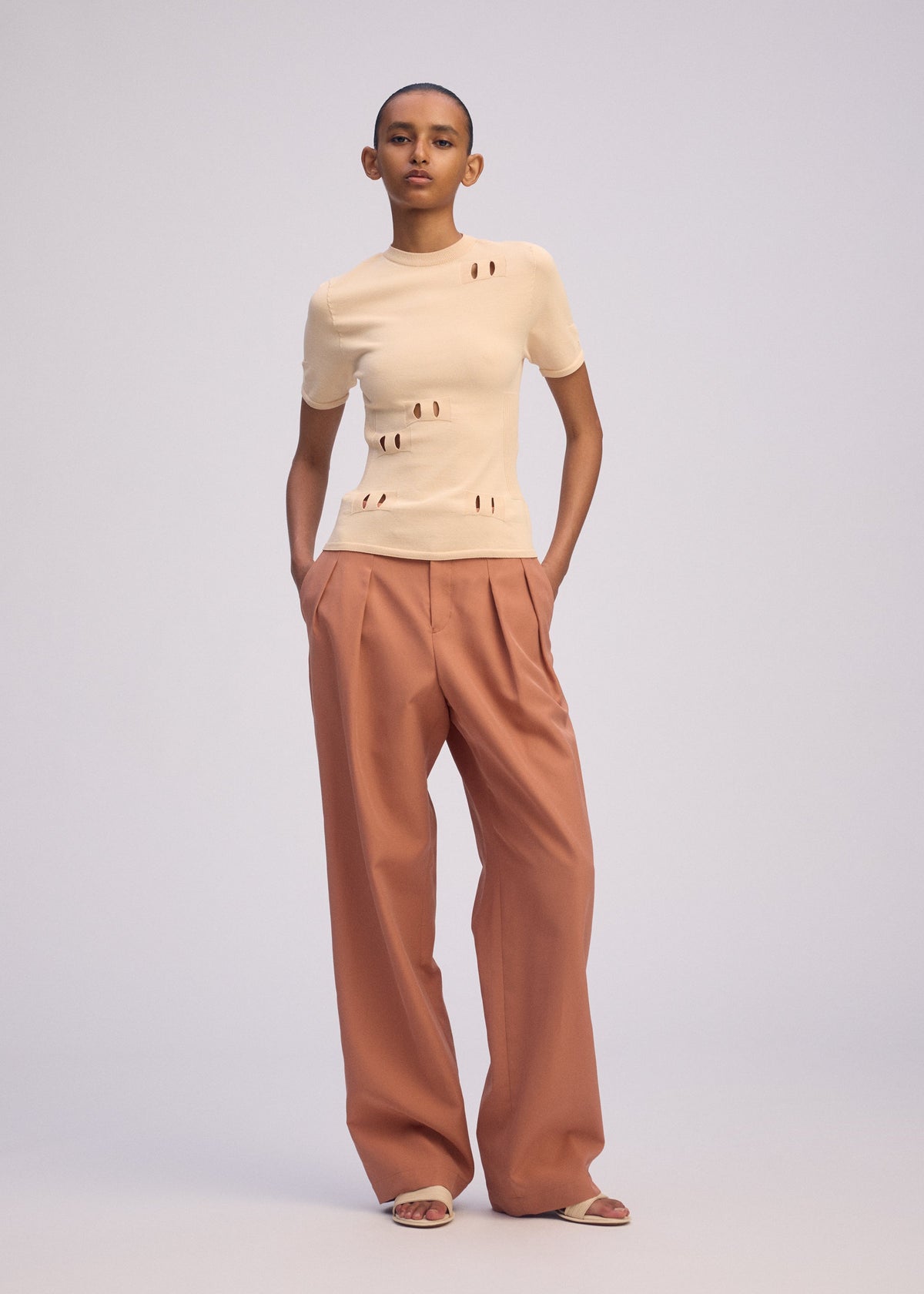 A model wears the ISSEY MIYAKE FLUTTERING PANTS trousers.