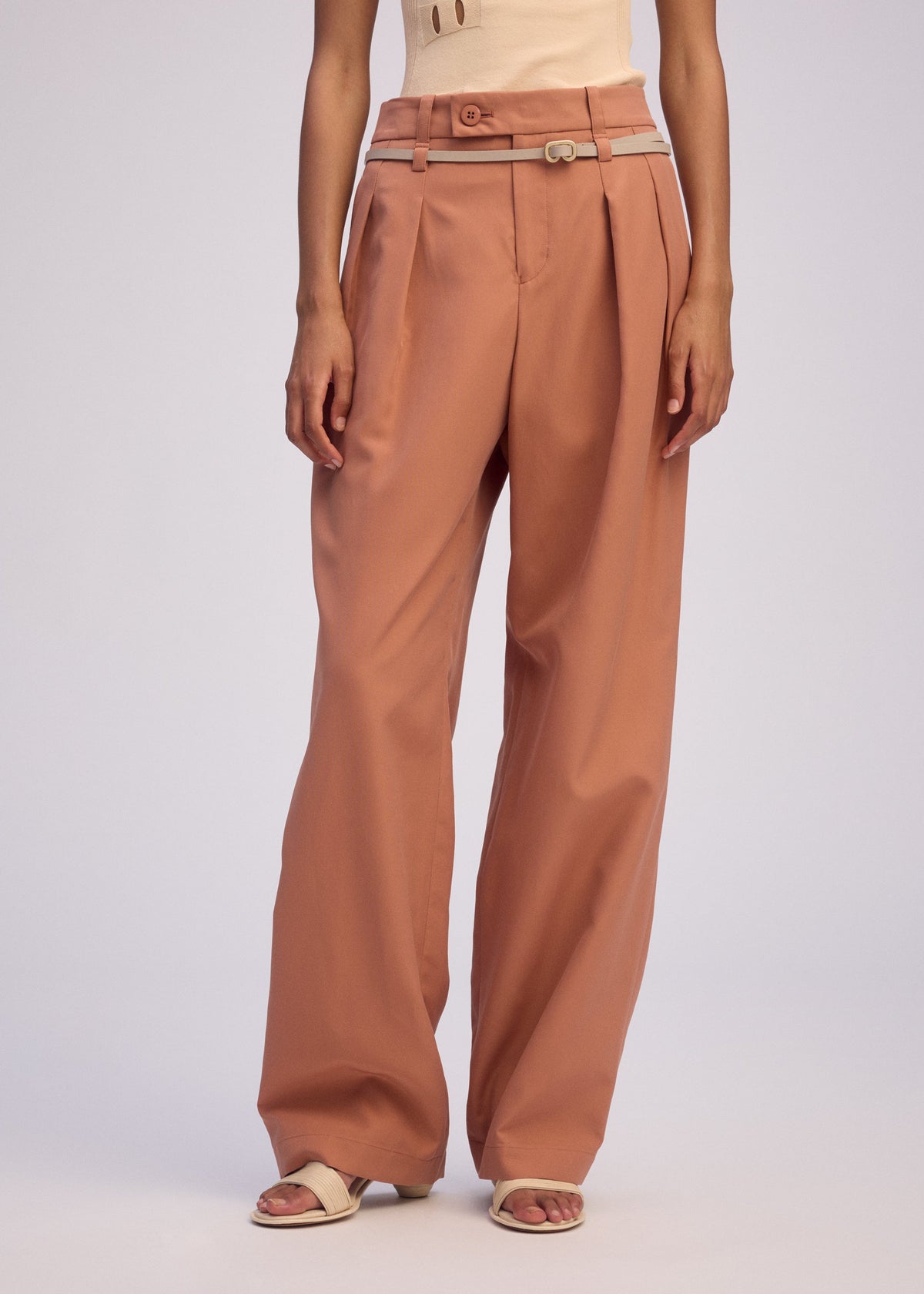 A model wears the ISSEY MIYAKE FLUTTERING PANTS trousers.