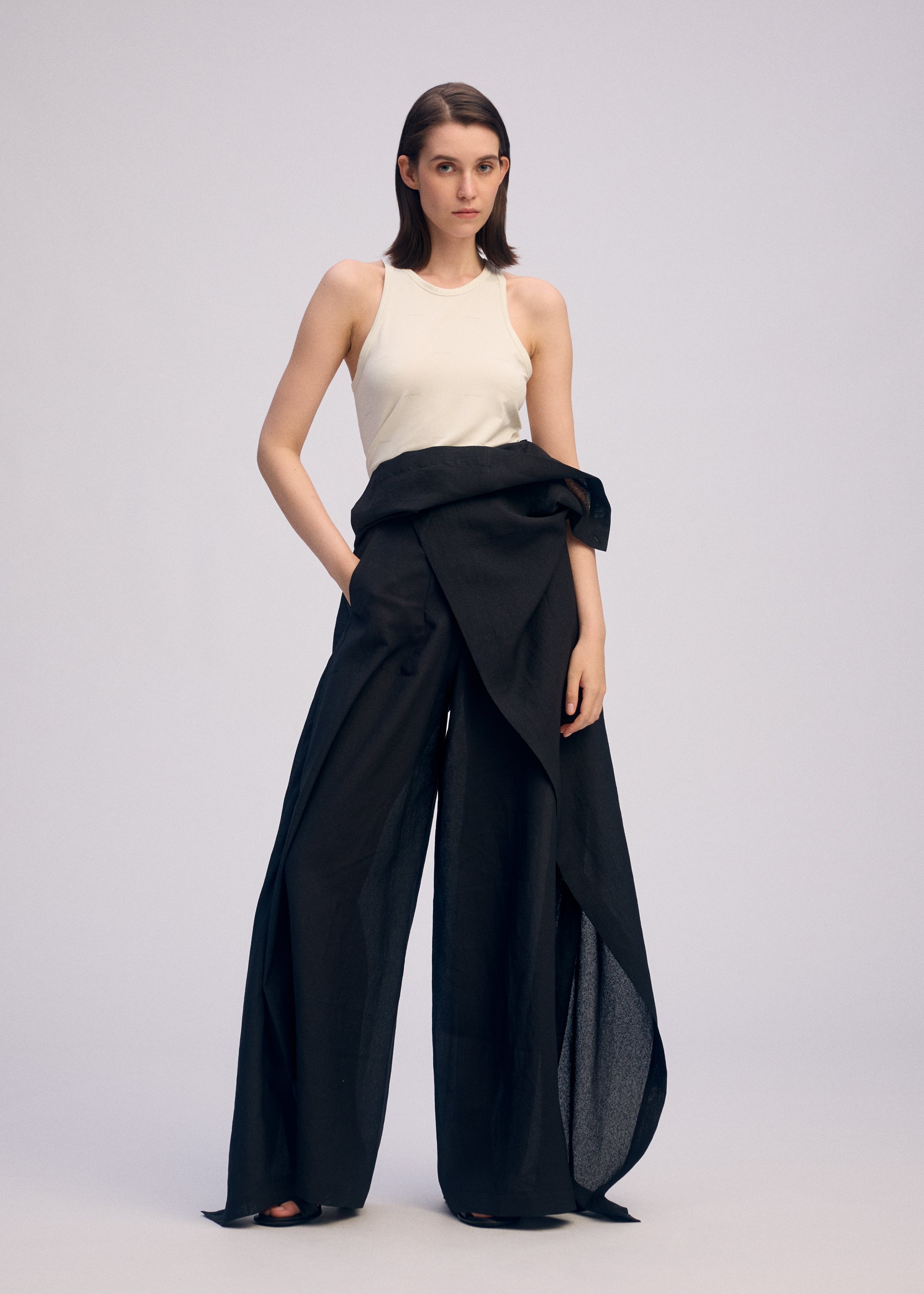 A model wears the ISSEY MIYAKE ALL SQUARES trousers.