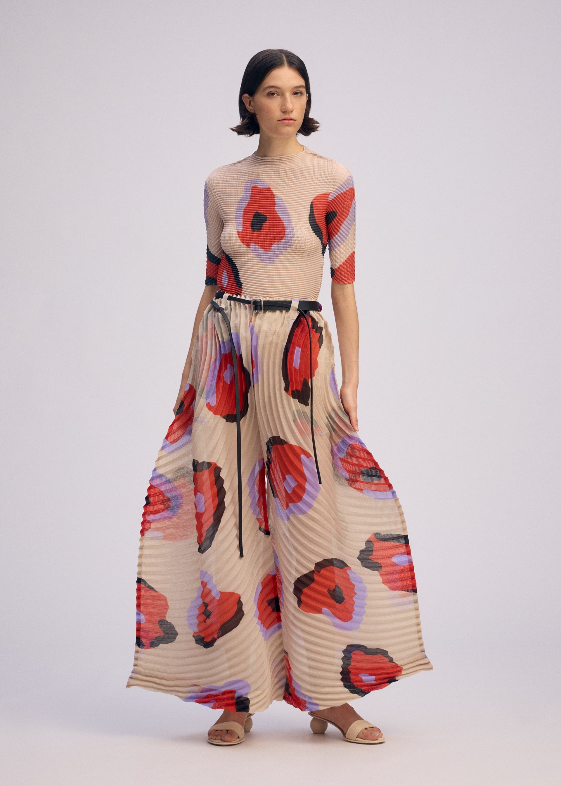 A model wears the ISSEY MIYAKE VERVE trousers.