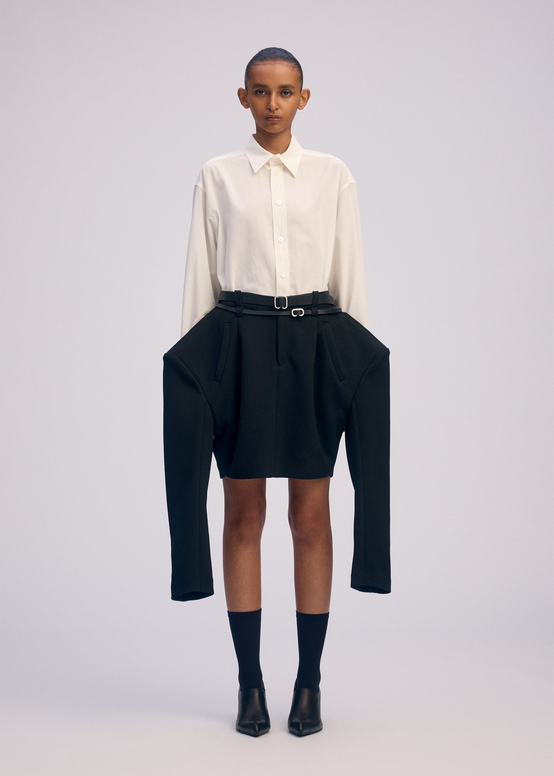 A model wears the ISSEY MIYAKE ARMS clothing.