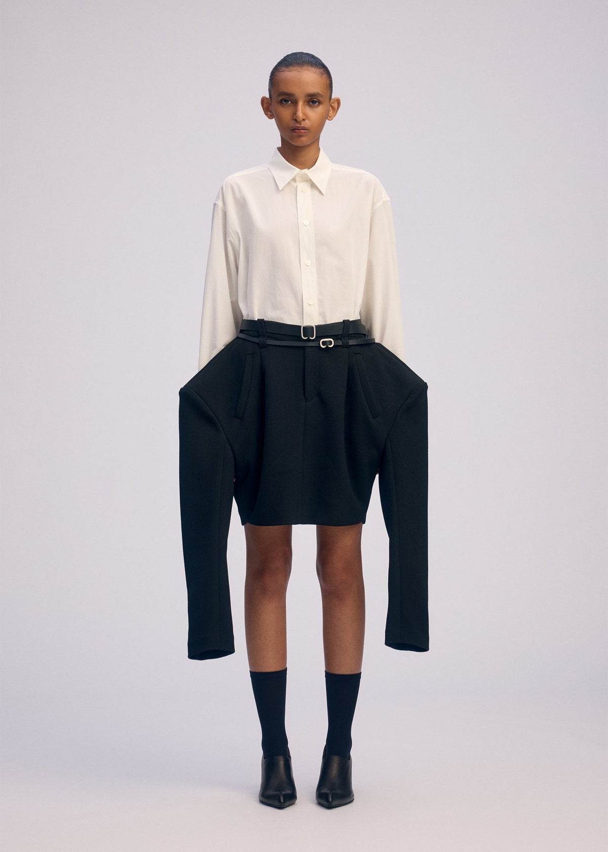 A model wears the ISSEY MIYAKE ARMS clothing.