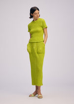 A model wears the ISSEY MIYAKE WAVELET ENSEMBLE skirt.